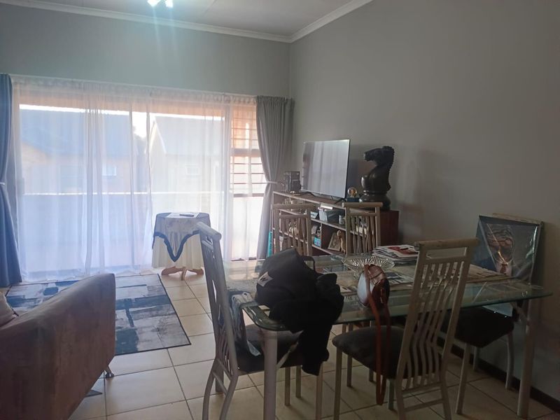 Open plan living and dining area featuring tiled flooring and a large sliding glass door providing access to the exterior.