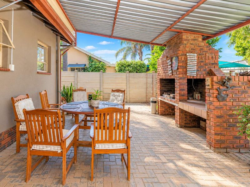 Covered outdoor patio featuring a brick built-in braai and paved flooring, ideal for alfresco dining and entertaining.
