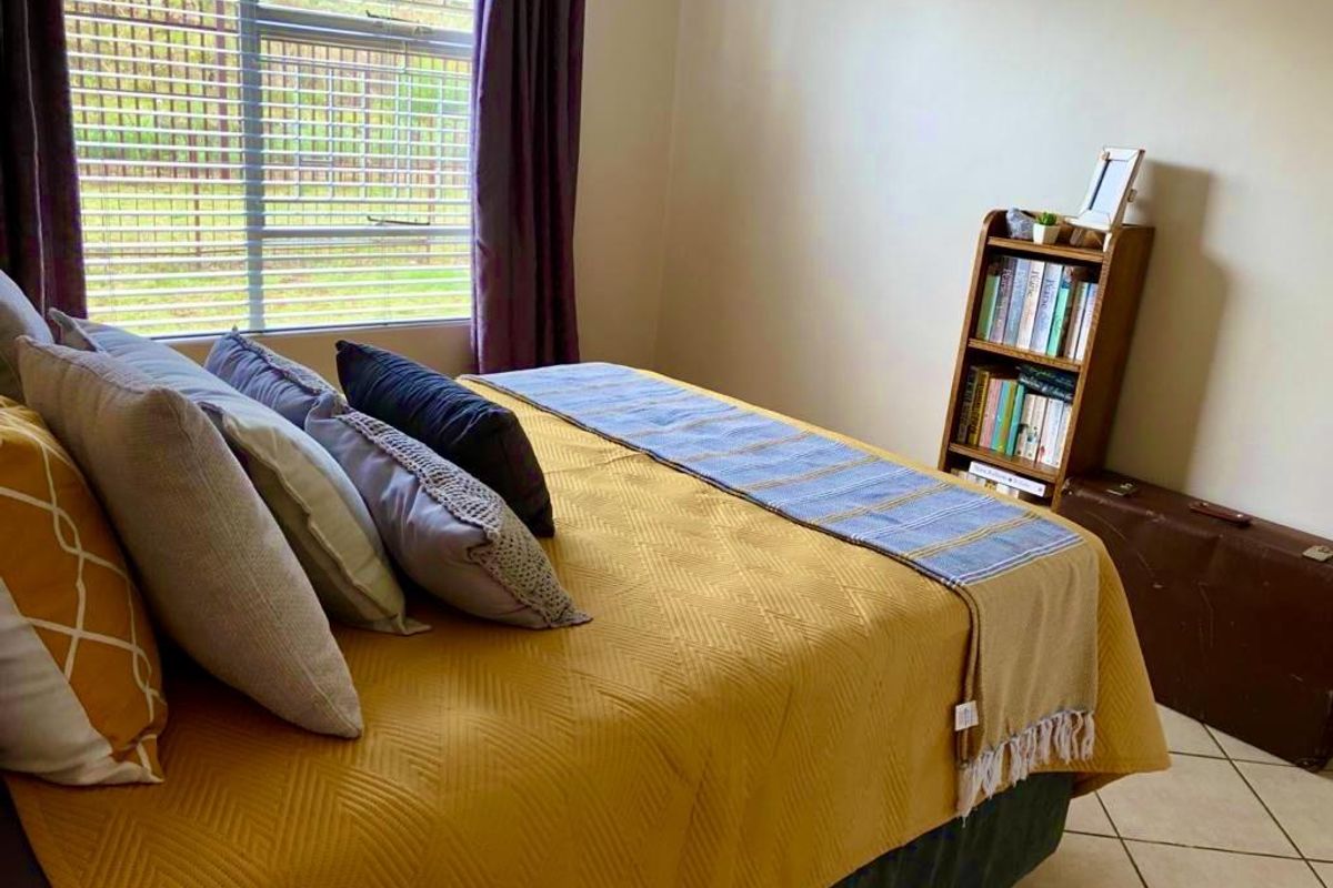 A bedroom featuring tiled flooring and a window with natural light, providing a functional and comfortable living space.