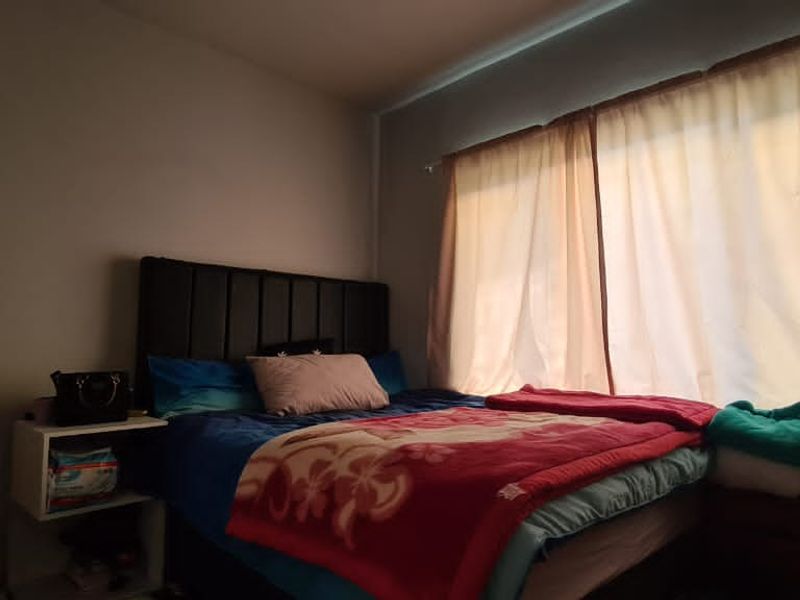 A standard bedroom featuring a window with installed curtain rails, providing natural light to the space.