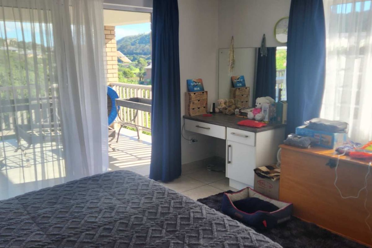 A bedroom featuring large sliding glass doors that open onto a private balcony with scenic views.