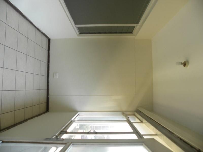 A simple, empty balcony area featuring tiled flooring and large sliding glass doors, providing a clean canvas for outdoor living space.