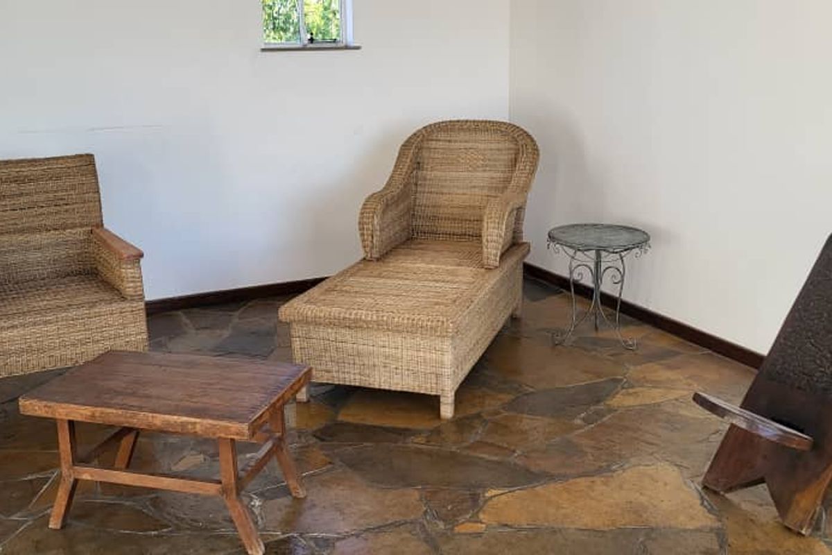 A living area featuring rustic flagstone flooring and neutral walls, providing a blank canvas for interior design updates.