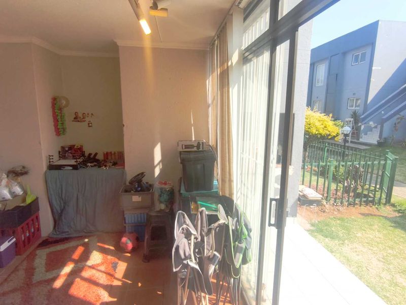 A sun-filled enclosed patio area featuring tiled flooring and large sliding glass doors that provide direct access to the garden.