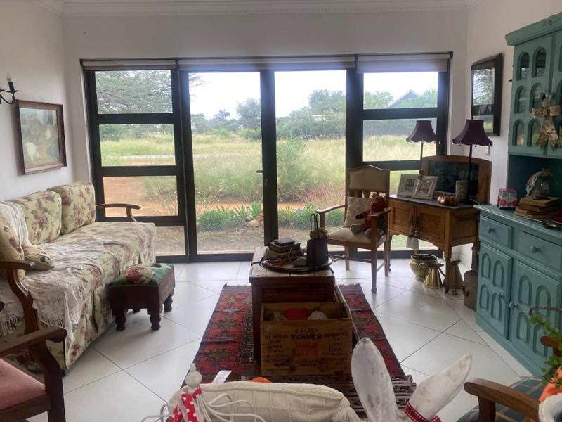 A bright living room featuring large glass sliding doors that provide natural light and views of the surrounding landscape.