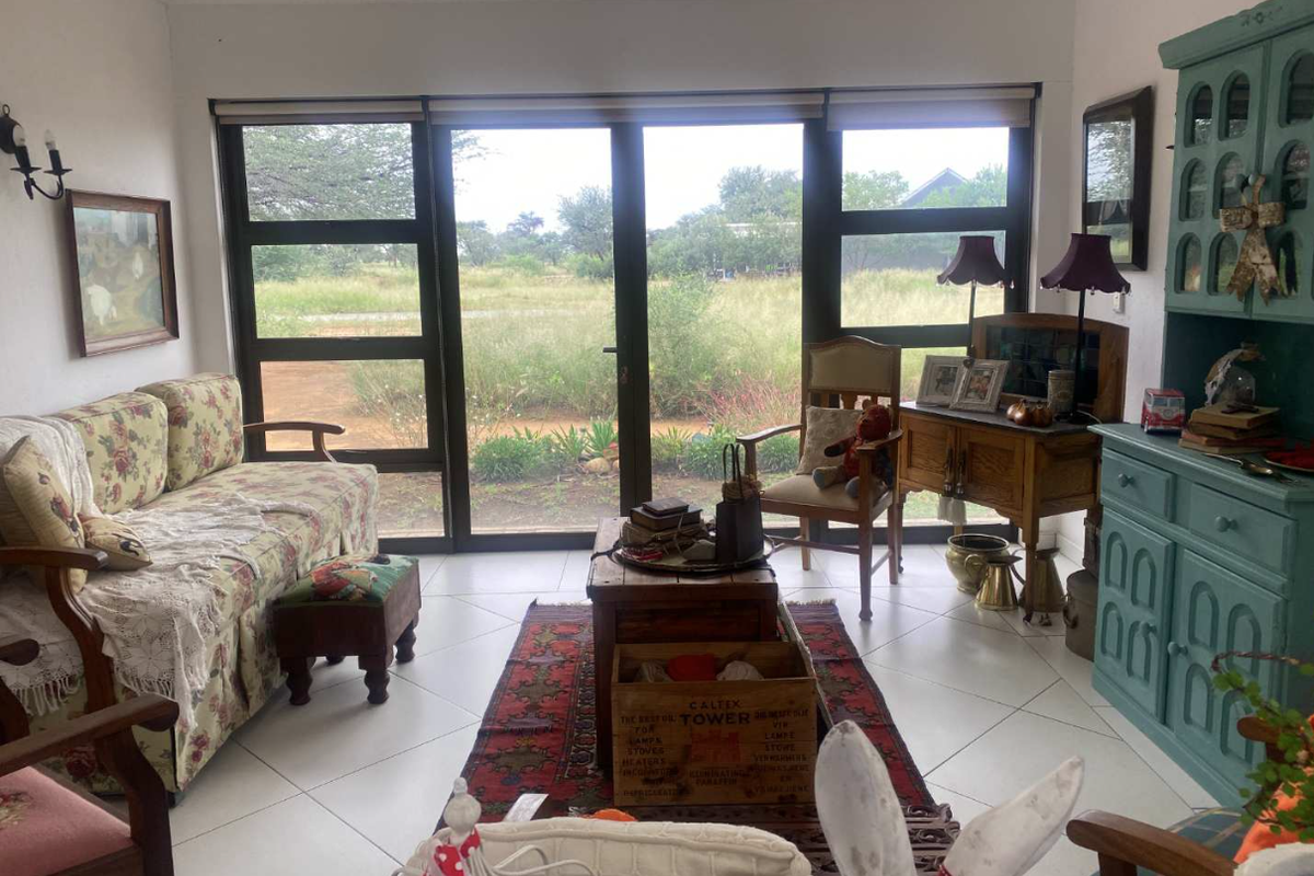 A bright living room featuring large glass sliding doors that provide natural light and views of the surrounding landscape.