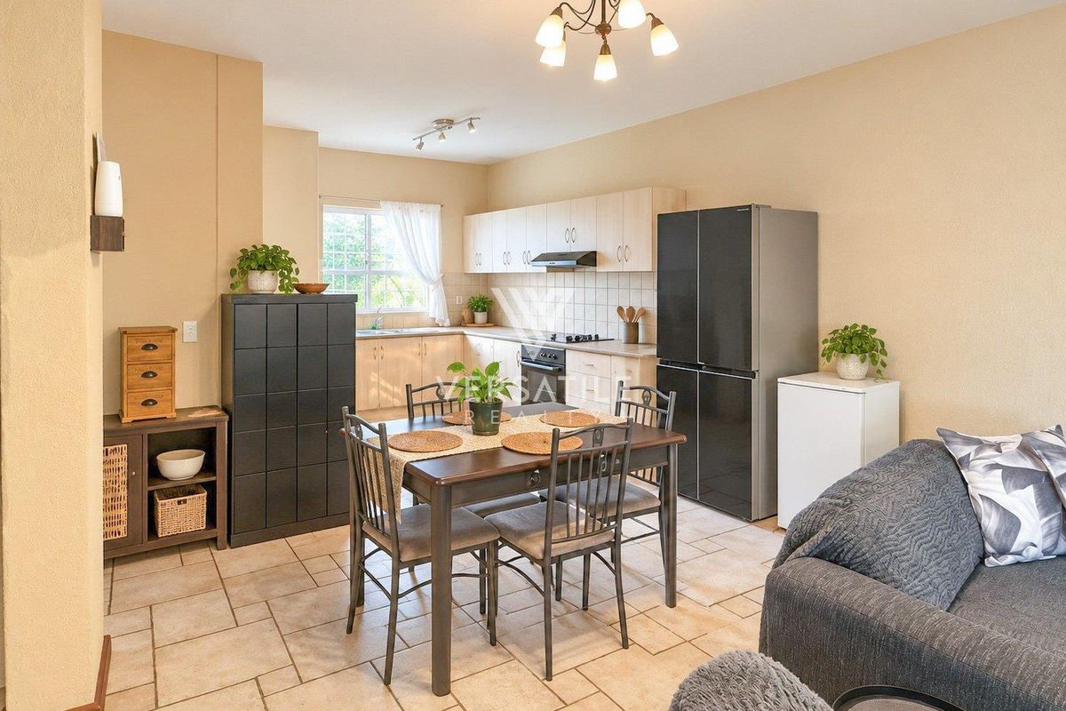 Open-plan kitchen and dining area featuring light wood cabinetry, tiled flooring, and integrated cooking appliances, creating a functional and connected living space.