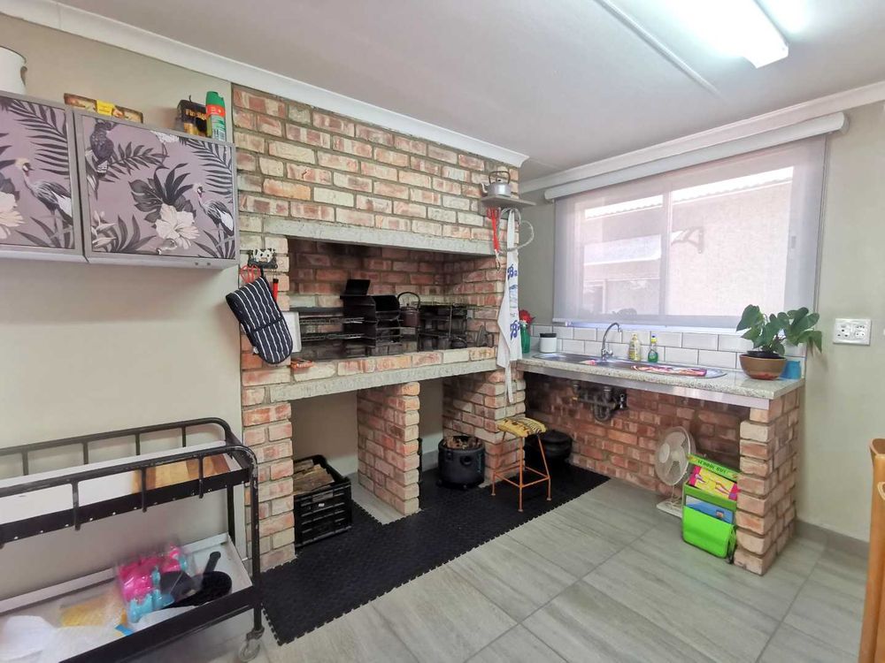 NEXT TO THE OPEN-PLAN KITCHEN WITH LOUNGE IS THIS INDOOR ENTERTAINMENT/FAMILY  ROOM WITH BUILT-IN BRAAI 