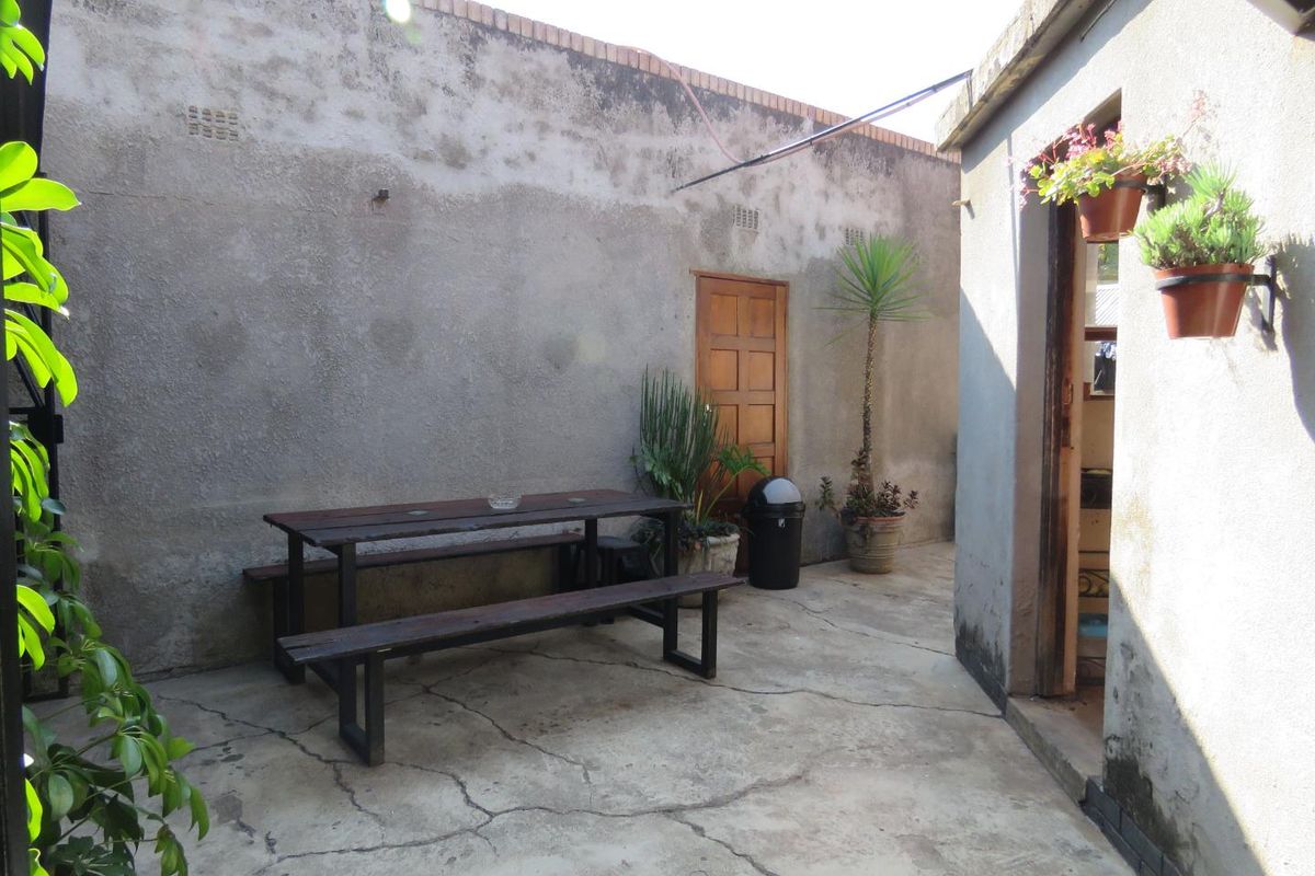 A private rear courtyard area featuring concrete paving and high boundary walls, providing a secluded outdoor space accessible from the main dwelling.