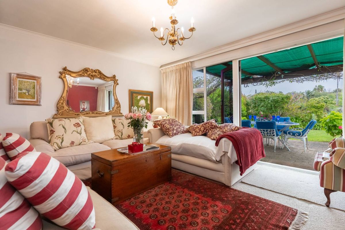 A comfortable living room featuring large sliding glass doors that provide direct access to a covered patio and garden area.