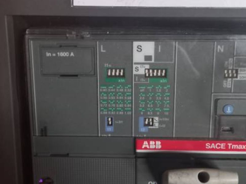 Close-up view of an industrial ABB SACE Tmax electrical circuit breaker panel with technical specifications displayed.