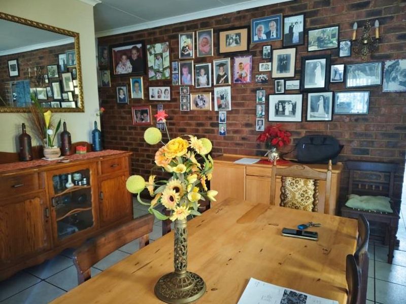A dining room featuring an exposed brick feature wall and tiled flooring, providing a traditional foundation for interior updates.