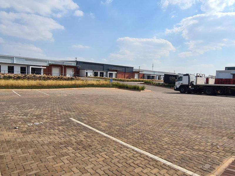 Wide-angle view of an industrial park featuring paved parking bays and multiple warehouse units with loading access.