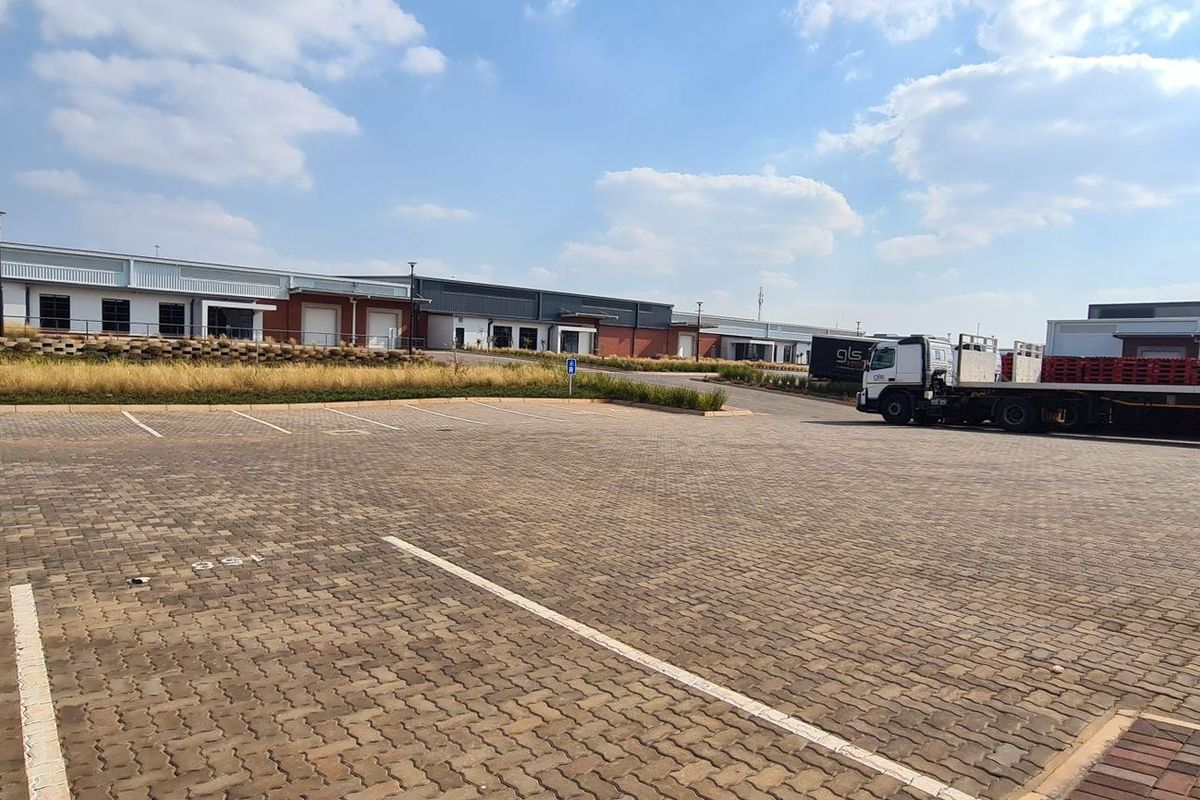 Wide-angle view of an industrial park featuring paved parking bays and multiple warehouse units with loading access.