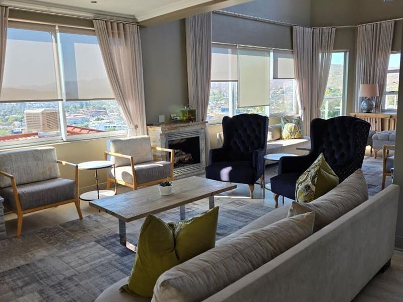 Spacious living room featuring a fireplace, large windows with panoramic views, and a built-in window seat, offering a bright and comfortable atmosphere.