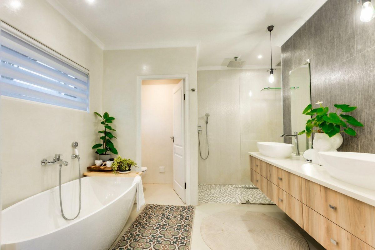 Modern bathroom featuring a freestanding bathtub, walk-in glass shower, and a double vanity with contemporary fixtures and stylish tiling.
