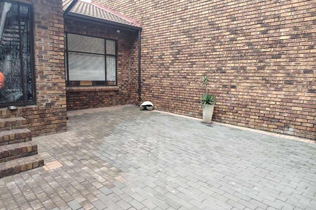 A private paved courtyard area featuring face-brick walls and direct access to the main dwelling.