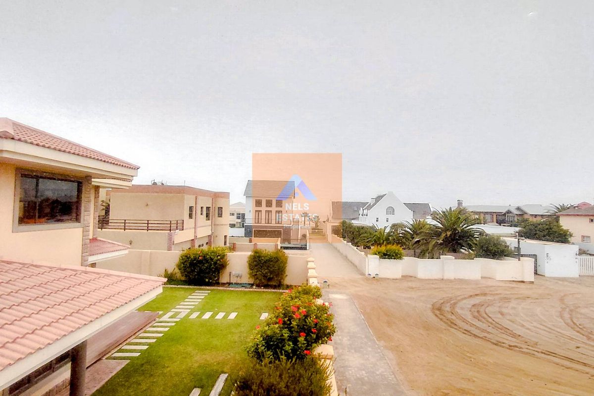 Elevated view of the residential estate grounds, featuring landscaped garden areas, paved pathways, and surrounding property architecture.