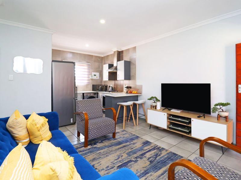 An open-plan living and kitchen area featuring tiled flooring, modern cabinetry, and a functional layout suitable for comfortable townhouse living.