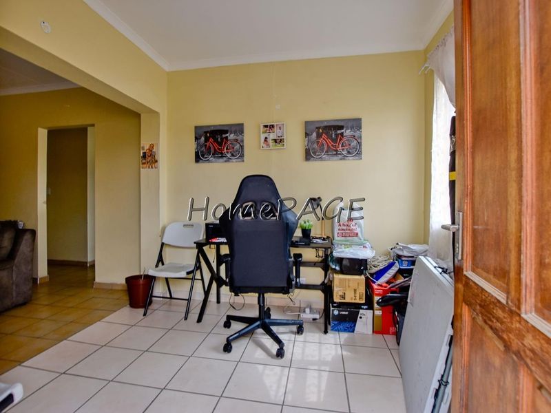 A functional office space featuring ceramic floor tiles and coved cornicing, providing a versatile area for work or study.