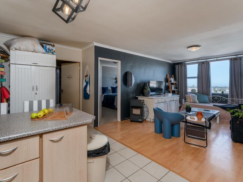 Open-plan living area featuring a kitchen with laminate countertops and a combined lounge space with large windows offering natural light and views.