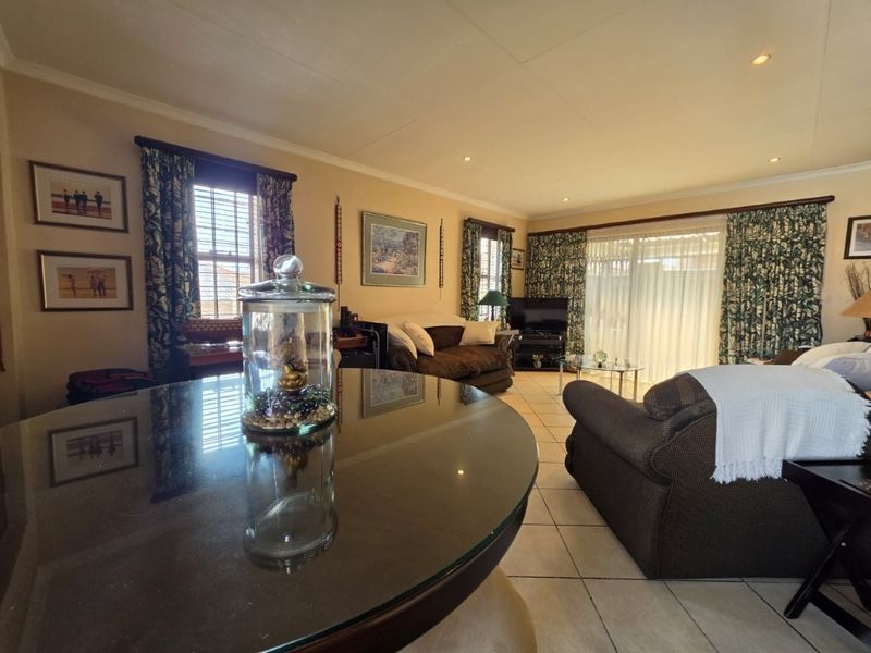 Spacious living area featuring tiled flooring, recessed lighting, and large sliding glass doors providing access to the outdoor space.