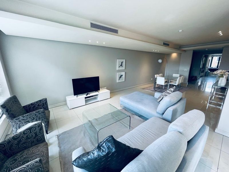 Spacious open-plan living and dining area featuring modern tiled flooring, recessed ceiling lighting, and integrated ducted air conditioning.