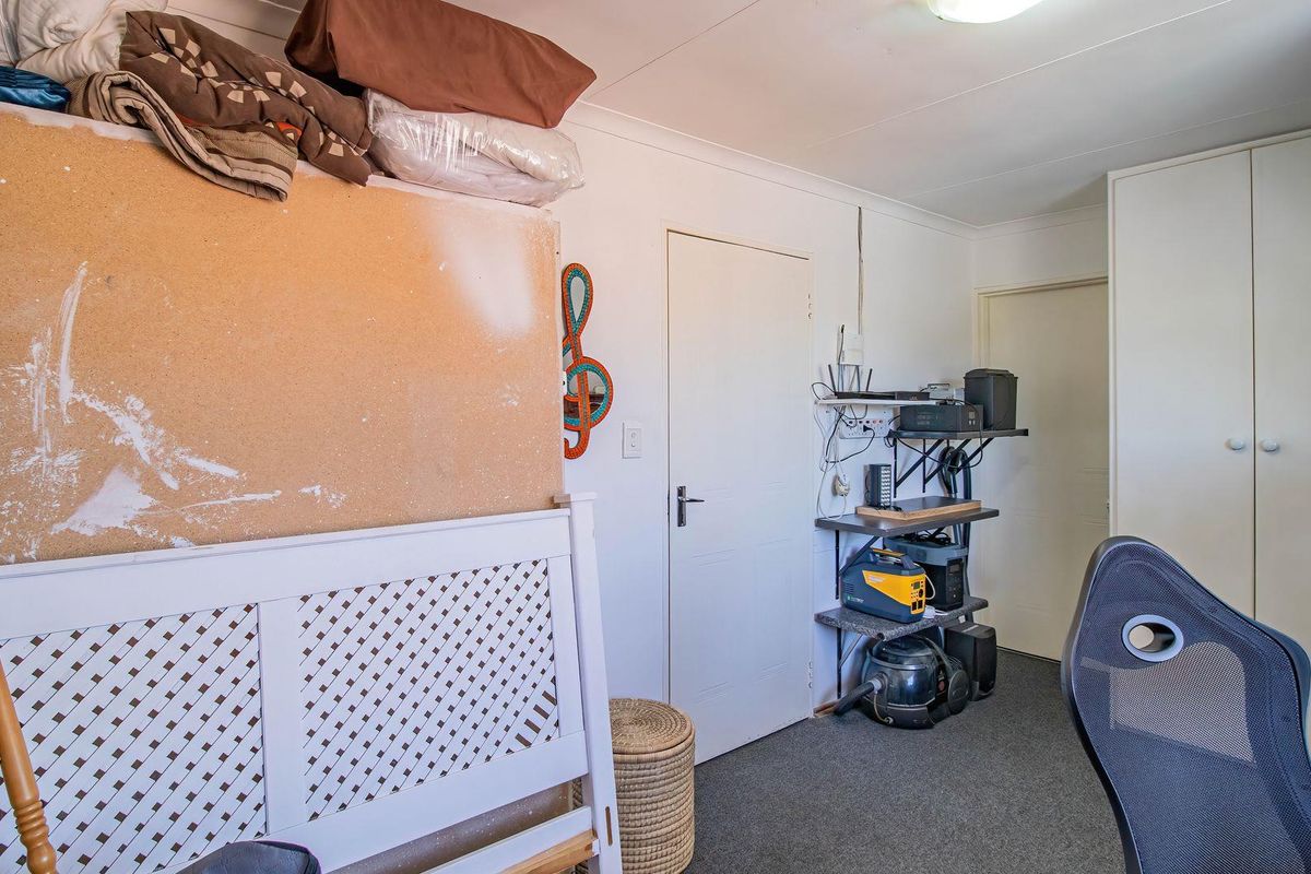 A bedroom featuring built-in cupboards, carpeted flooring, and coved ceiling details, offering a functional space ready for personalization.
