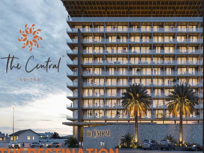 Modern multi-story hotel building featuring glass balconies, stone facade detailing, and contemporary architectural design.