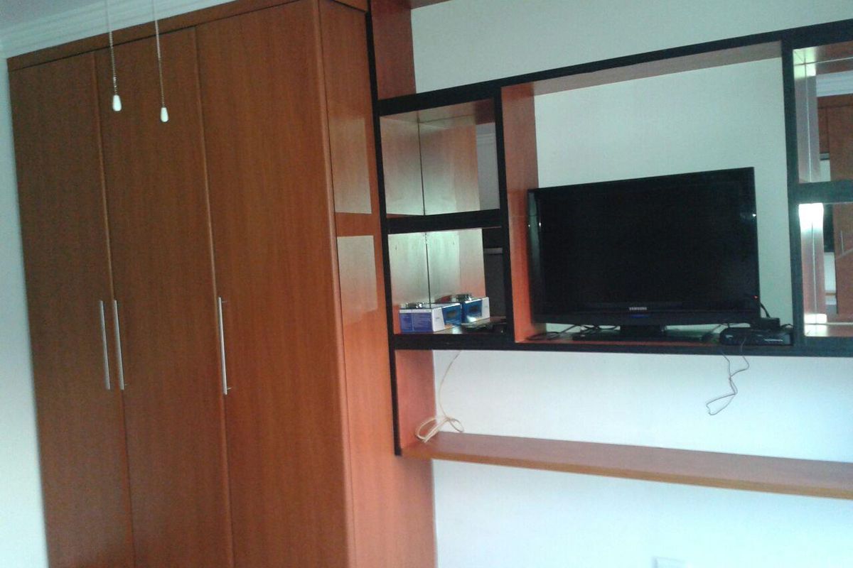 Bedroom featuring a large built-in wooden wardrobe and a matching integrated shelving unit with display space.