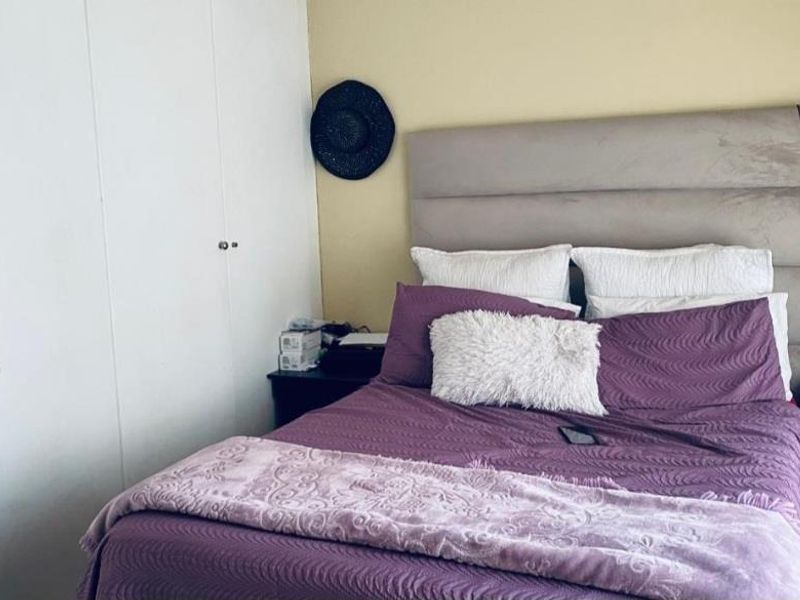 A functional bedroom featuring built-in cupboards and neutral wall finishes, providing a comfortable and practical living space.