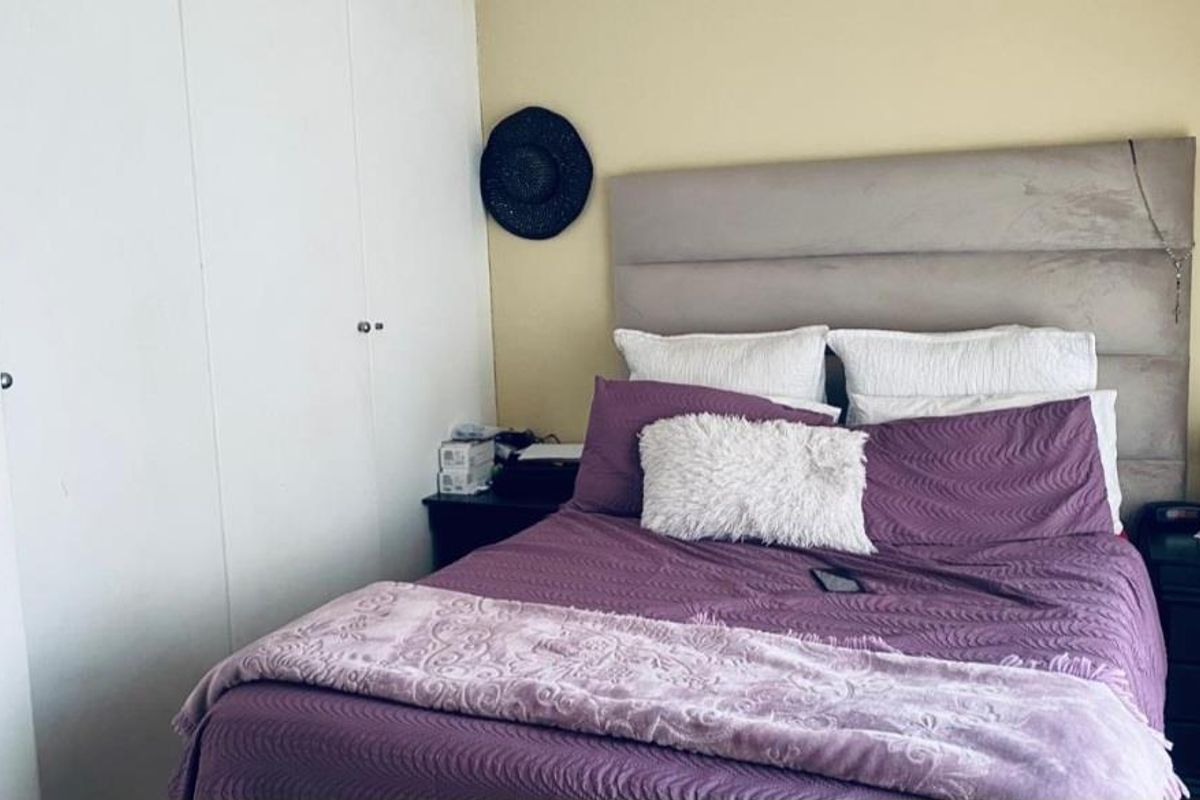 A functional bedroom featuring built-in cupboards and neutral wall finishes, providing a comfortable and practical living space.
