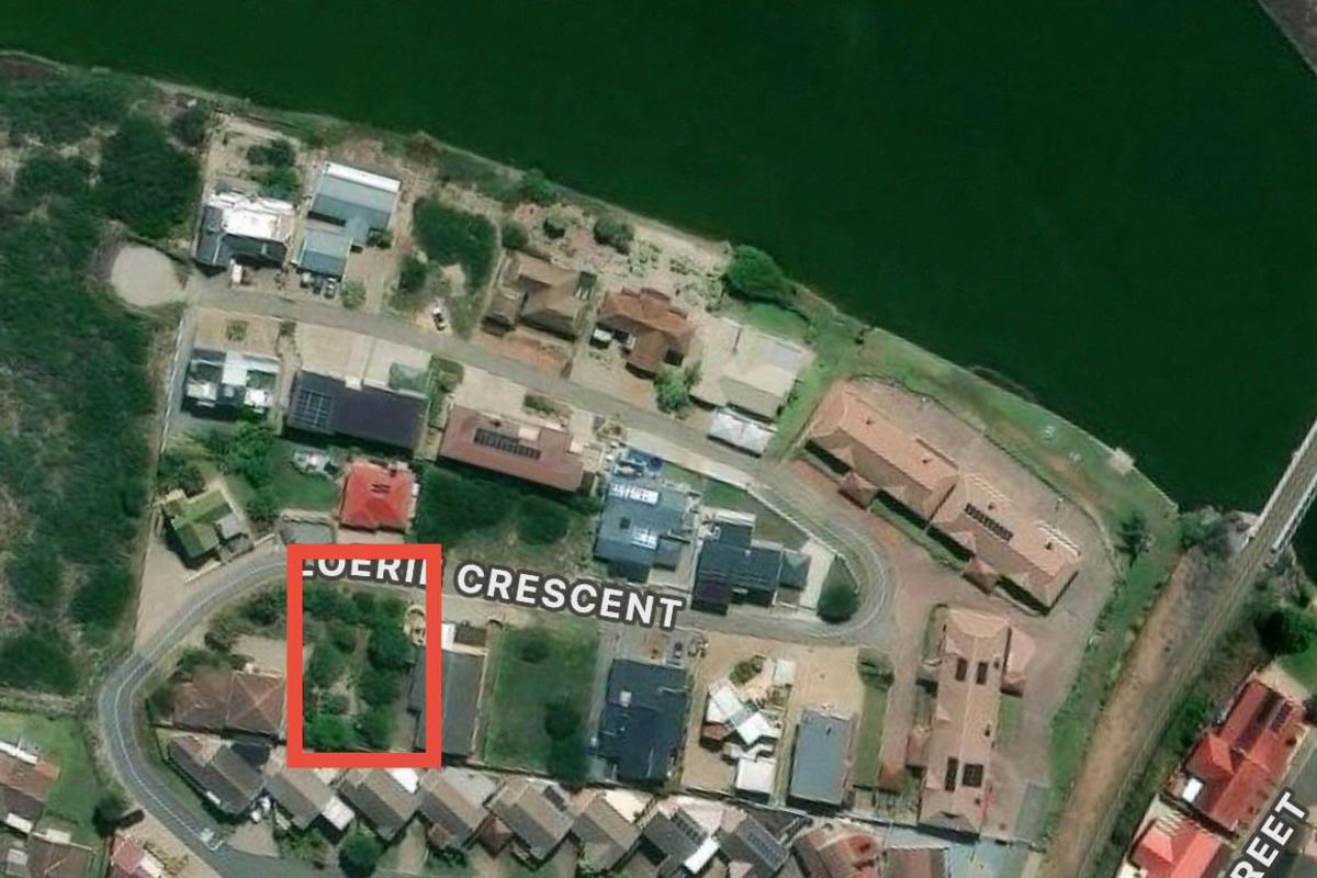 An aerial view of a residential vacant land plot located within a suburban neighborhood, highlighting its position and surrounding context.
