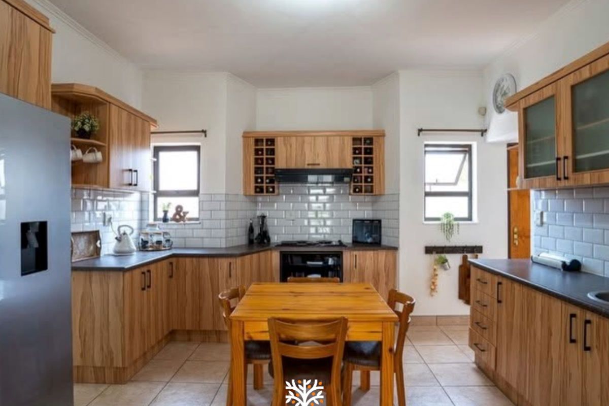 A well-maintained kitchen featuring wooden cabinetry, subway tile backsplash, dark countertops, and integrated appliances, offering a functional and warm cooking space.