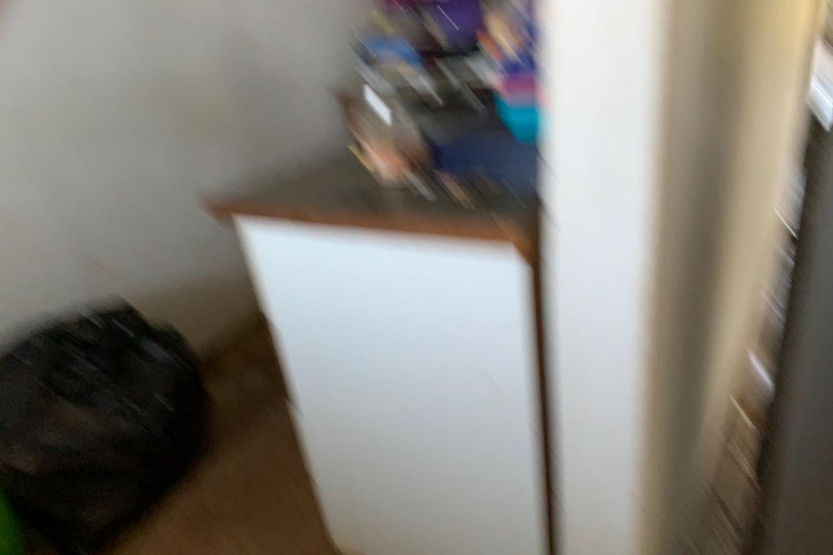 A blurry view of a kitchen area featuring built-in cabinetry and a countertop.