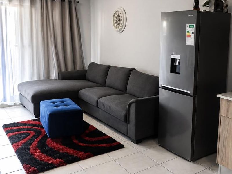 Open plan living area featuring neutral tiled flooring and a sliding glass door providing access to the exterior.