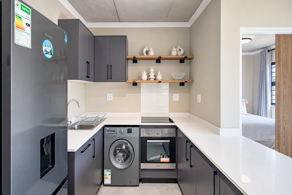 Modern kitchen with contemporary cabinetry and open-plan living in an iQ Meerendal apartment.