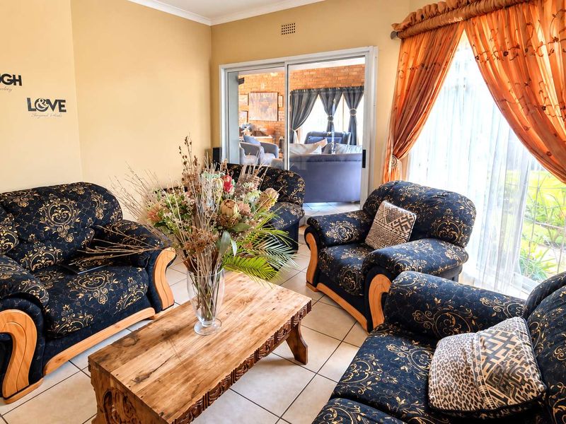 A comfortable living room featuring tiled flooring and a large sliding glass door that provides natural light and access to the patio area.