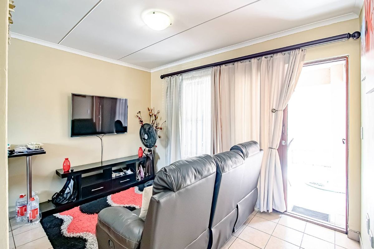 A living room featuring tiled flooring and a sliding glass door providing access to an outdoor area.