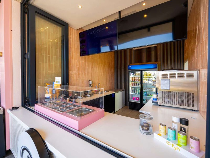 Modern commercial service counter featuring tiled walls, integrated refrigeration, and a clean, functional layout suitable for a food and beverage business.