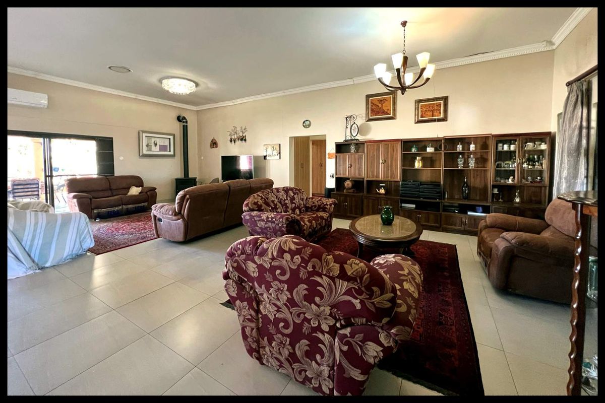 Spacious open-plan living area featuring tiled flooring, a built-in fireplace, and sliding door access to the outdoor patio.