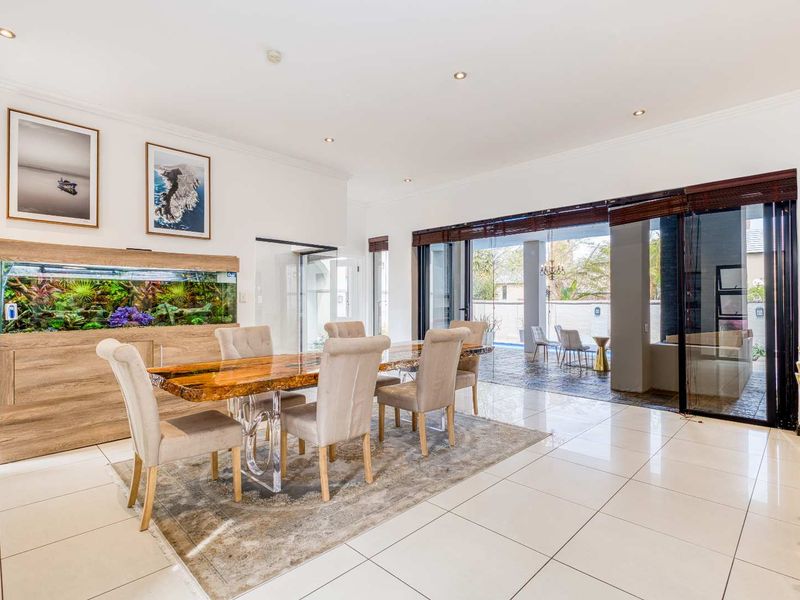 Spacious dining area featuring polished tiled floors, recessed lighting, and large sliding glass doors that open onto an outdoor patio area.