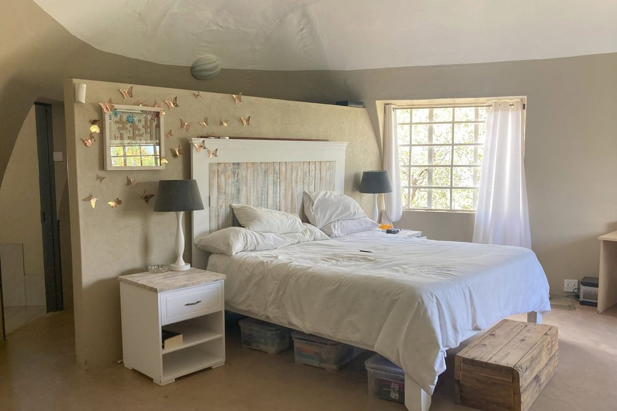 A bedroom featuring a unique partition wall design and a grid-style window, offering a distinct architectural layout.