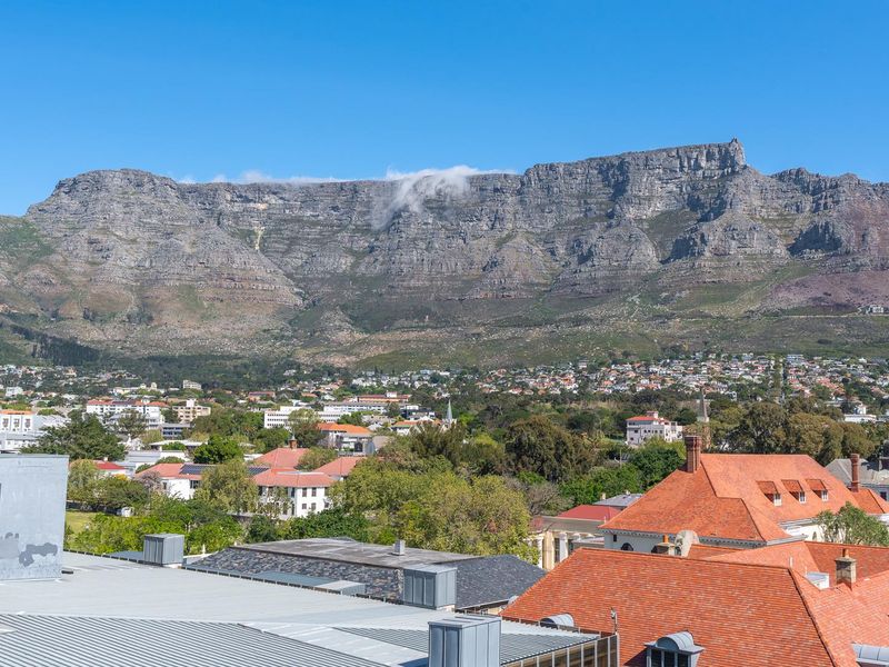 A clear, elevated view of Table Mountain overlooking the surrounding residential suburb and rooftops.