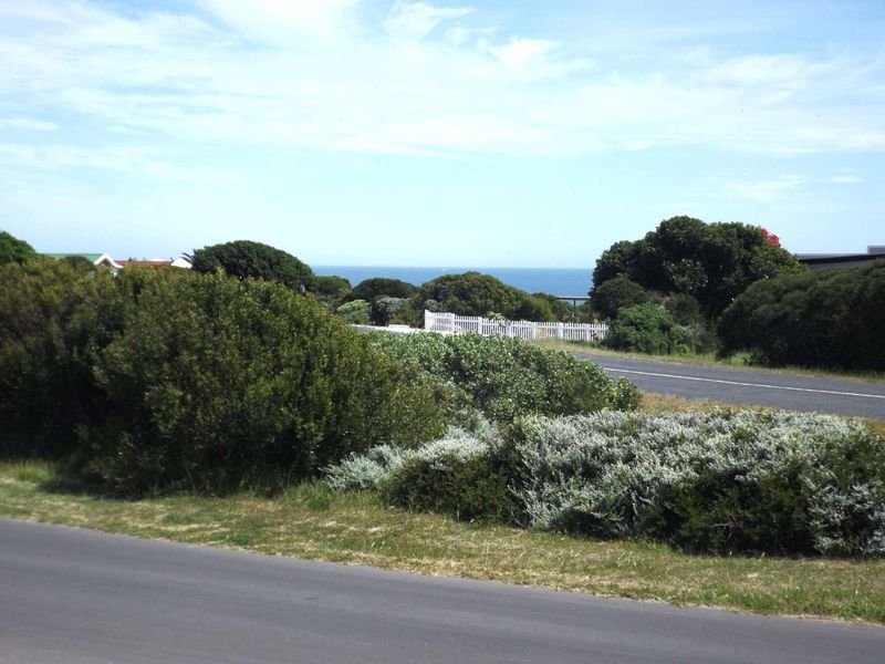 A scenic view of the coastal landscape featuring a paved road and natural vegetation, highlighting the property's proximity to the ocean.