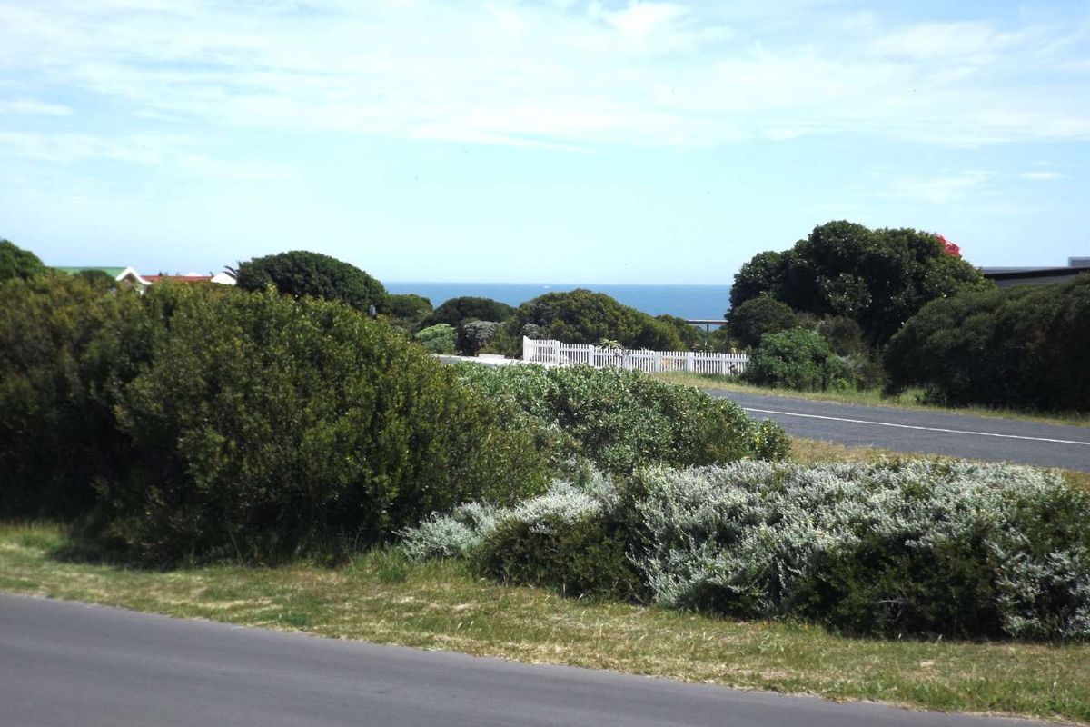 A scenic view of the coastal landscape featuring a paved road and natural vegetation, highlighting the property's proximity to the ocean.