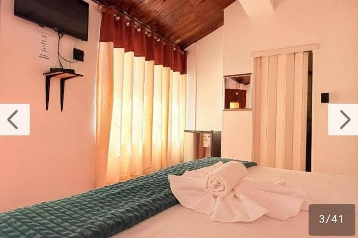 A bedroom featuring a timber-clad ceiling, a folding door, and a wall-mounted shelf.