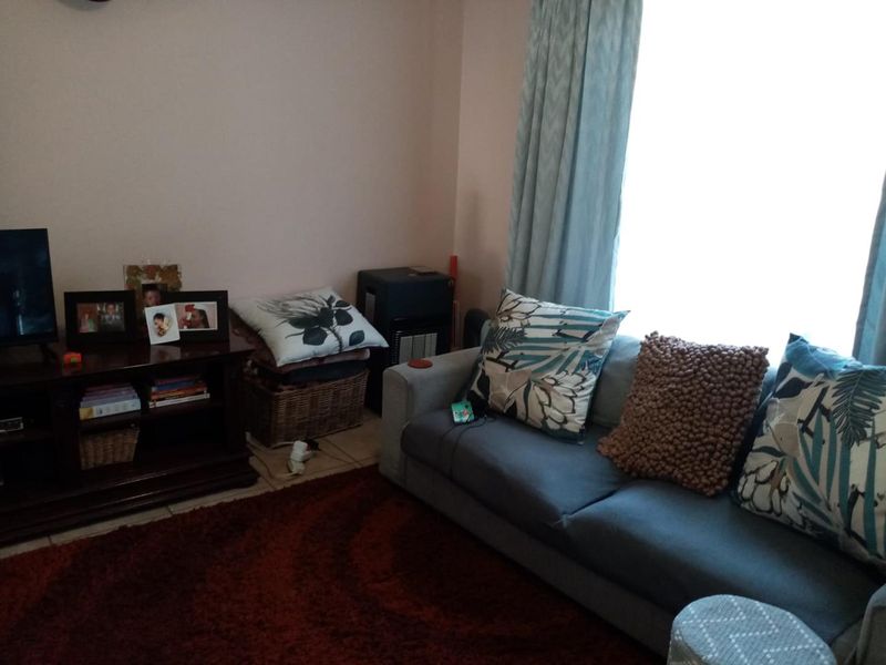 A living room area featuring tiled flooring and a built-in gas heater, providing a functional space for relaxation.