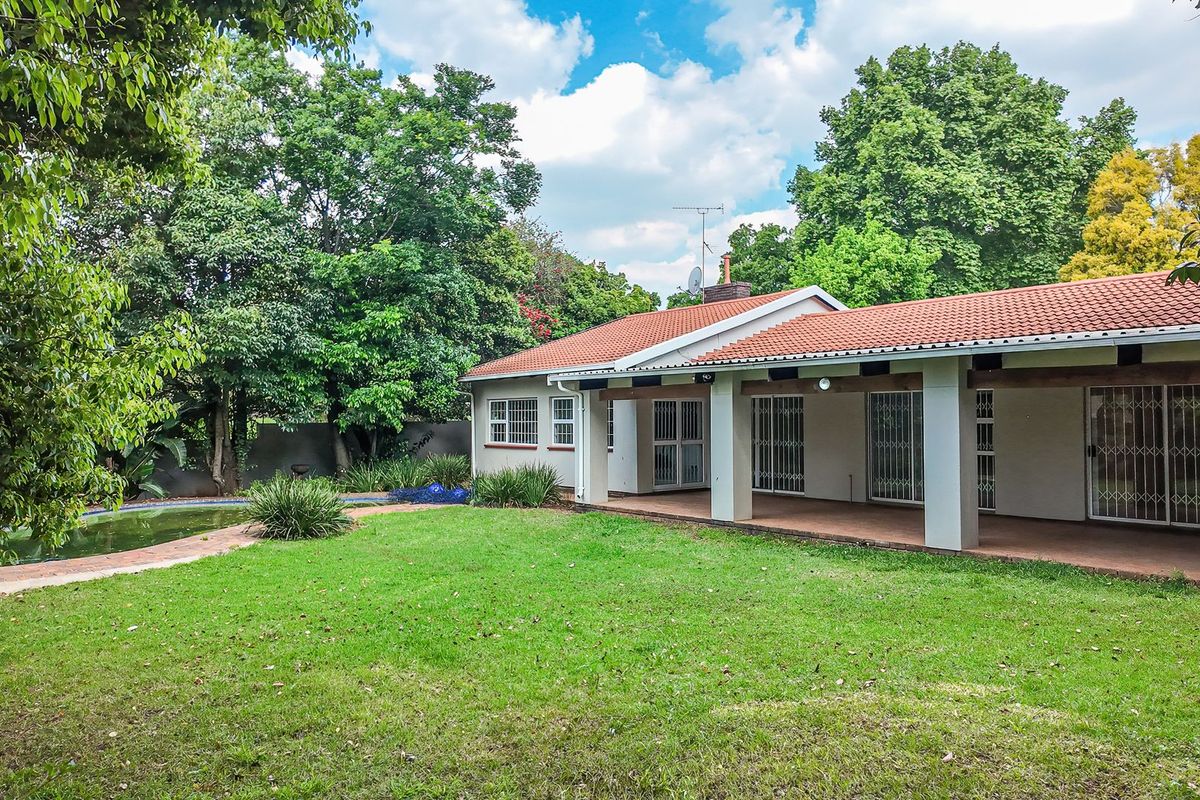 Rear view of the property featuring a covered patio, swimming pool, and a spacious garden area.
