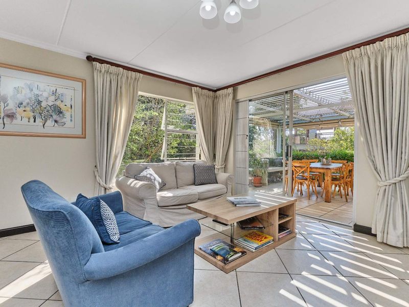 Bright living room featuring tiled flooring and large sliding glass doors that provide seamless access to the outdoor patio area.